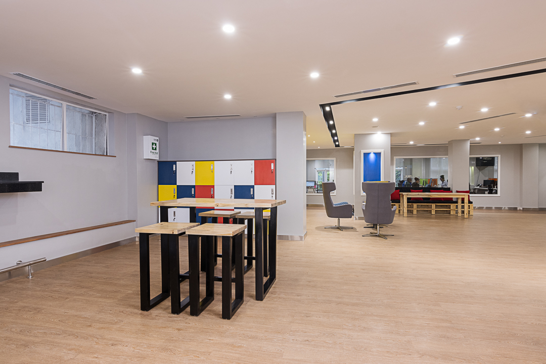 Open plan incubation area with different furniture organised in clusters, timber hardwood flooring and soft lighting in the Stanbic bank incubation centre designed by Arcs Africa