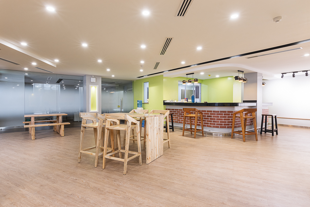 Open plan incubation area with different furniture organised in clusters, timber hardwood flooring and soft lighting in the Stanbic bank incubation centre designed by Arcs Africa