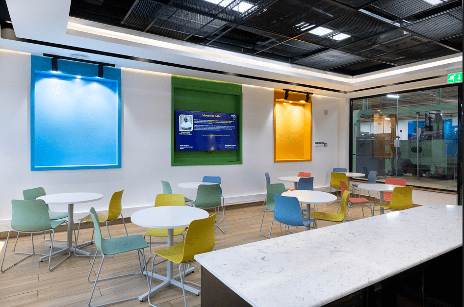 Office space showing colourful seats arranged around round tables distributed across room. Designed by Arcs Africa for BAT offices in Industrial area