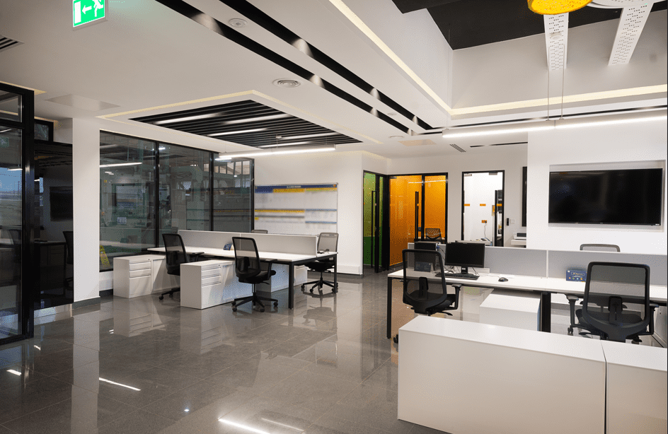 Office space showing desk and glass doors that stand out in green and yellow-tinted glass. Designed by Arcs Africa for BAT offices in Industrial area