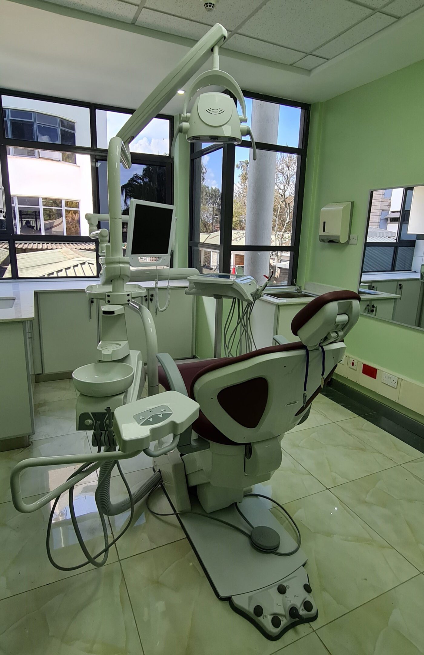 Interior of Karen Hospital dental unit showing dental chair and window with view to outside