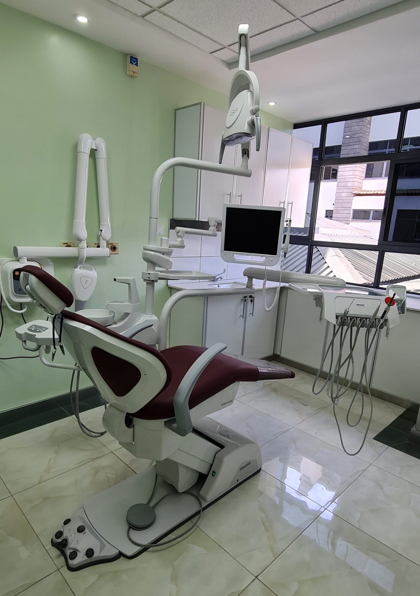 Interior of Karen Hospital dental unit showing dental chair and window with view to outside