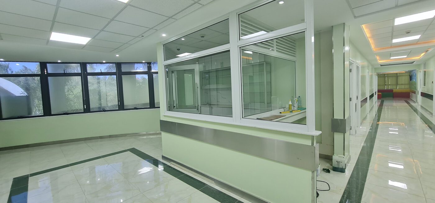 Interior image of Karen Hospital doctor's suite showing reception desk behind half glass wall and hallway